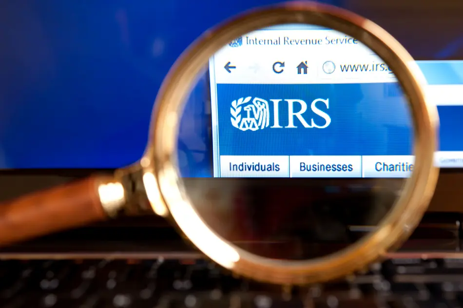 Close up to IRS( Internal Revenue Service) website through a magnifying glass on the laptop.