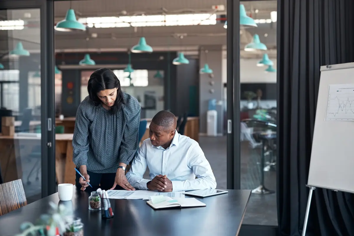 2 business professionals looking over some financial paperwork