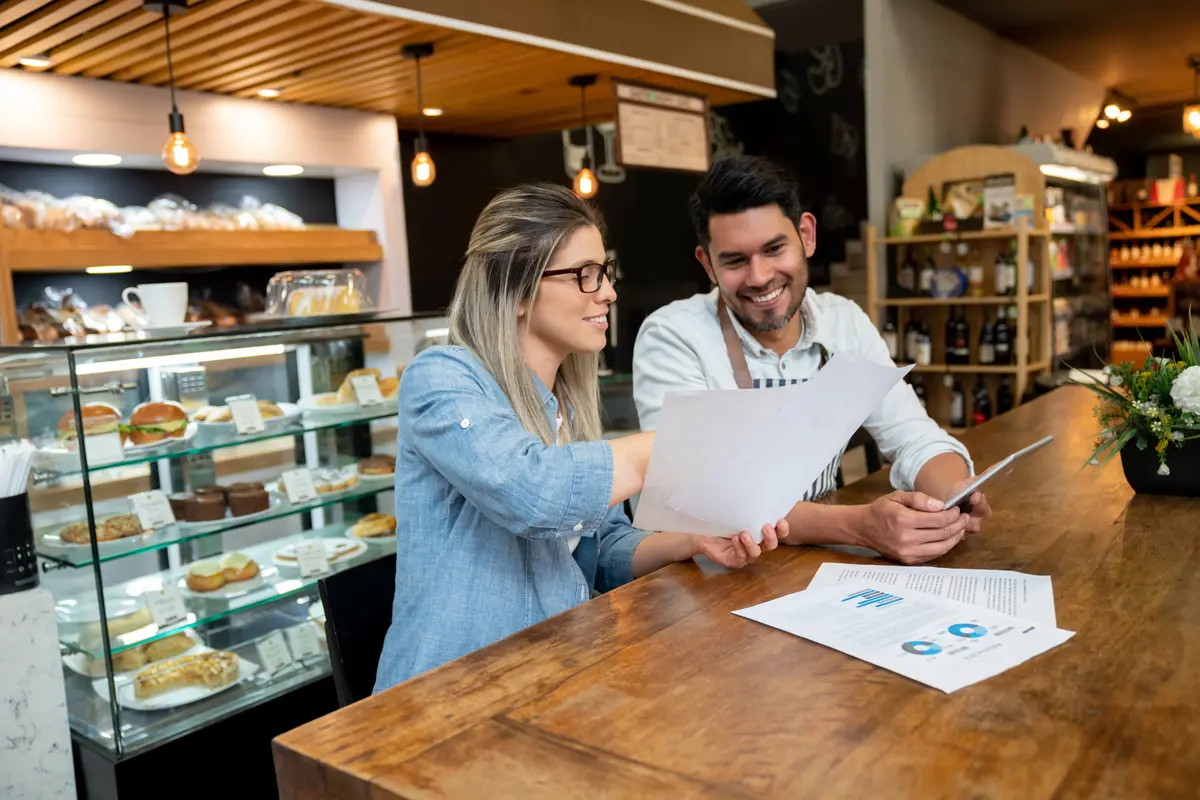 Accountant and bakery shop owner going over financials